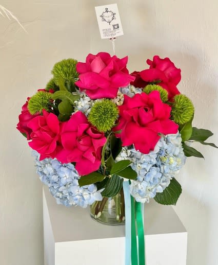 Bouquet of hot pink roses and blue hydrangeas in a glass vase