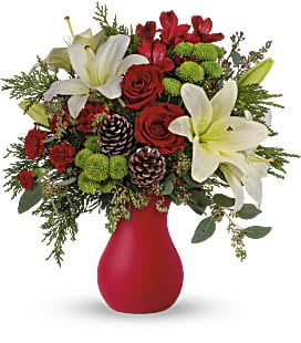 Red roses and white lilies in a red vase with pinecones