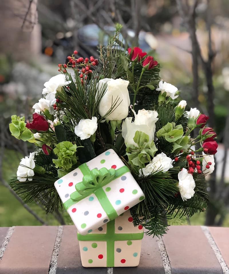 Holiday bouquet with white and red roses in a polka-dot gift box
