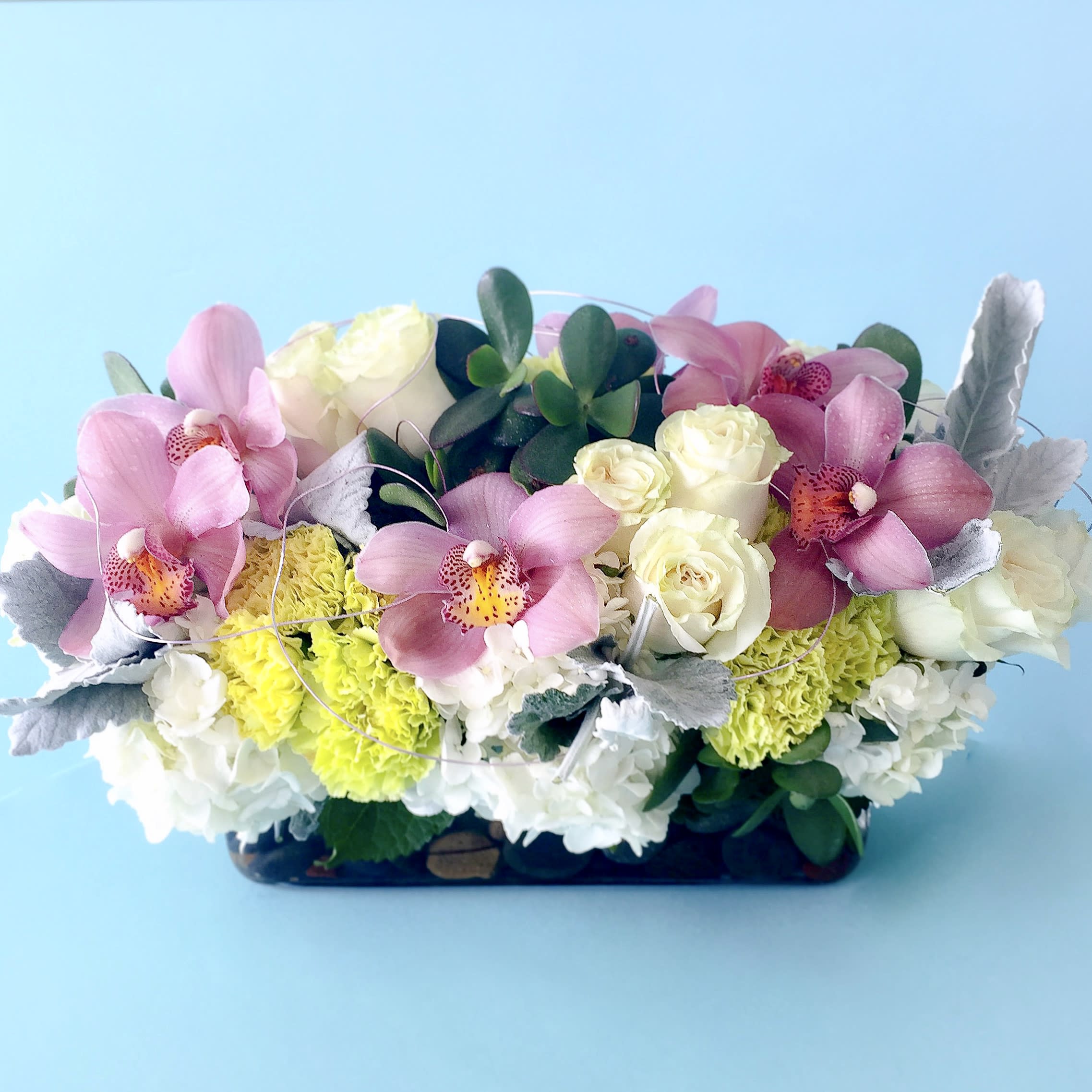 Pink orchids and white roses in a low rectangular arrangement