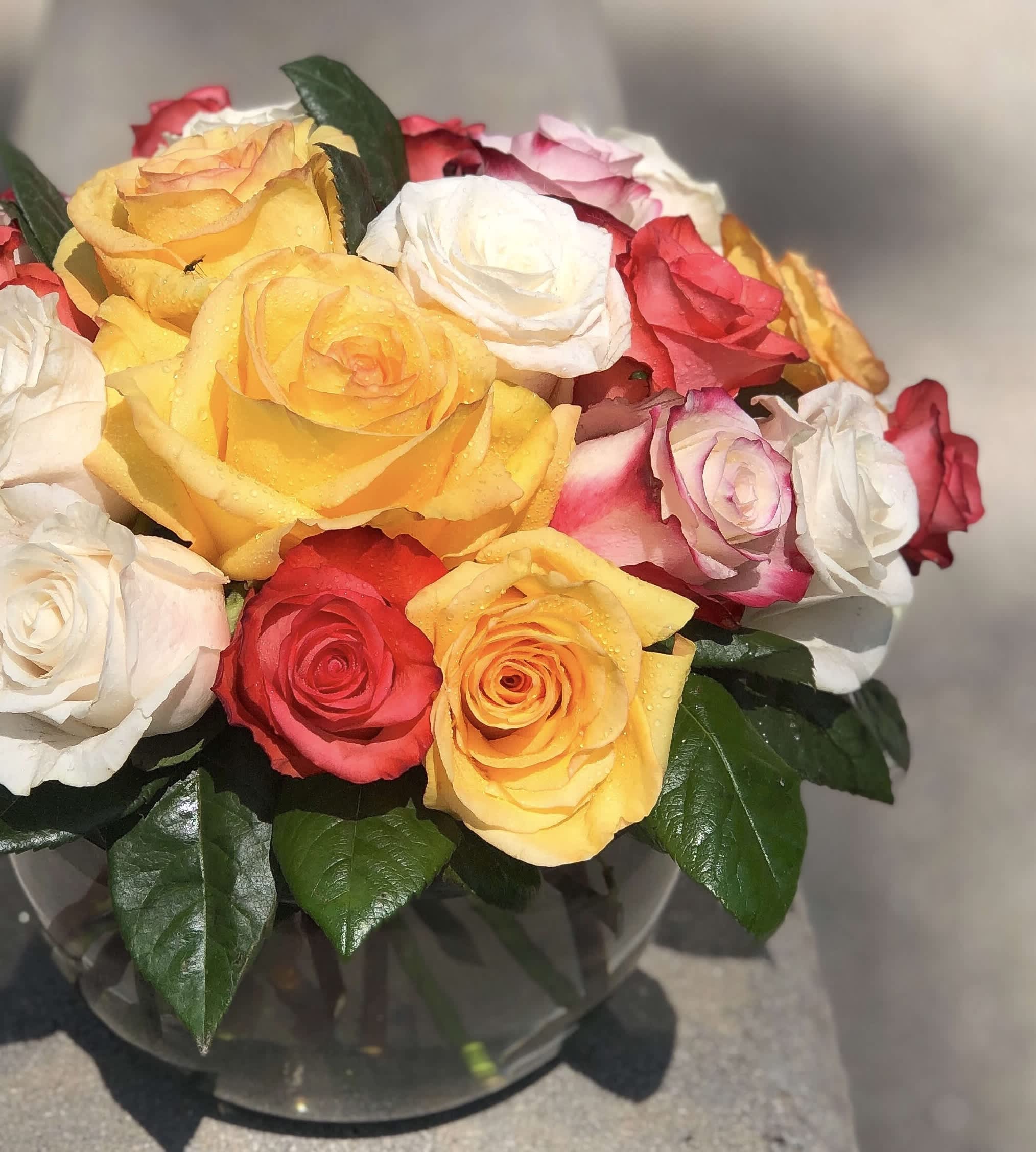 Bouquet of multicolored roses in a clear glass vase