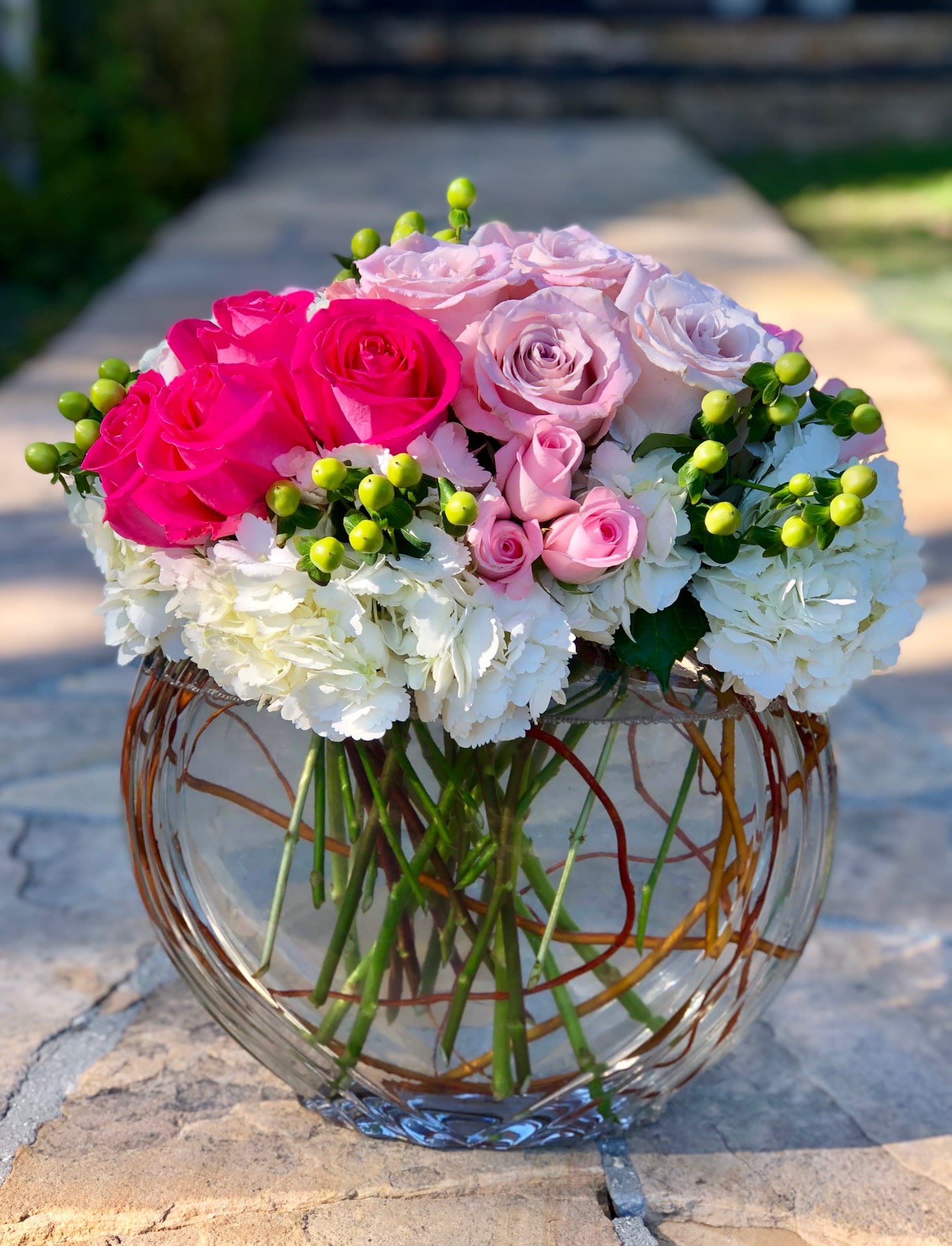 Pink and white roses in a round glass vase