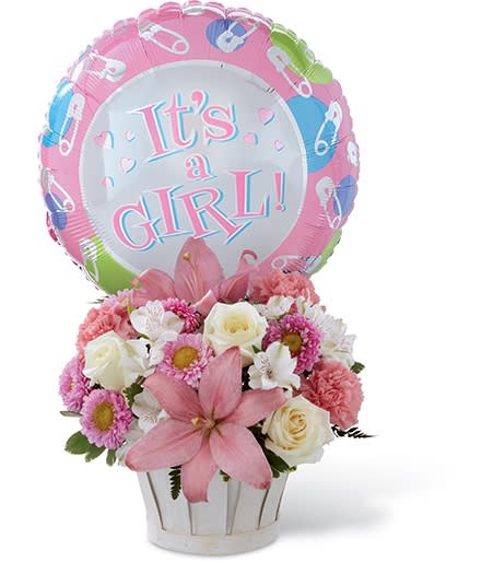 Pink and white flower arrangement with a "It's a Girl!" balloon