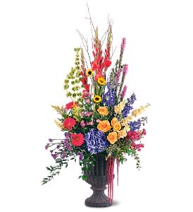 Tall mixed flower arrangement in a dark urn vase