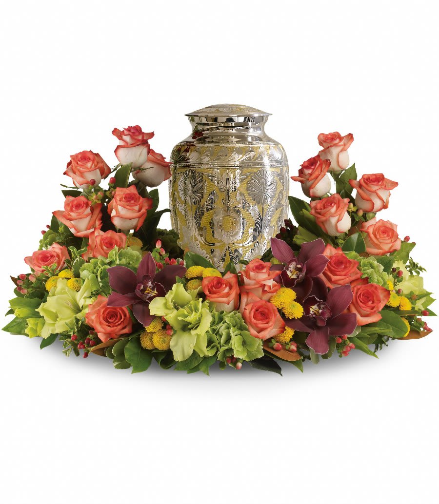 Floral urn arrangement with coral roses and orchids around a silver urn