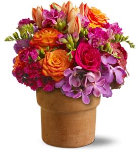 Bright mixed bouquet in a brown vase with orange, pink, and purple flowers
