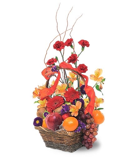 Basket arrangement with red and orange flowers, fruit, and ribbon