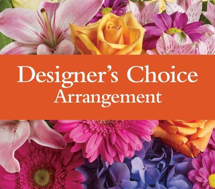 Colorful mixed flowers behind an orange label reading Designer's Choice Arrangement