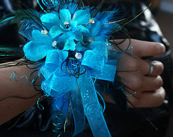 Blue floral wrist corsage with ribbon and feathers