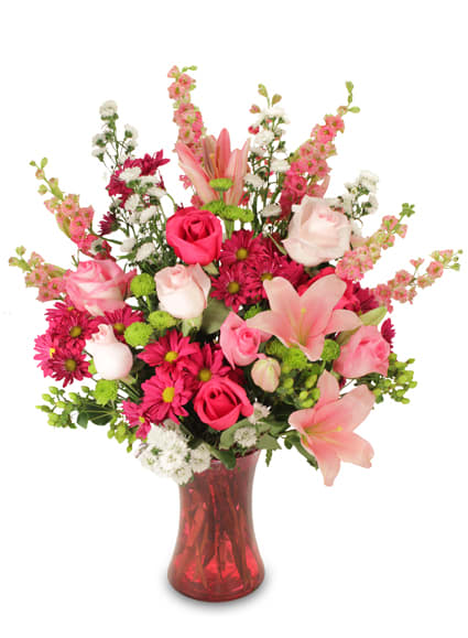 Pink and white mixed flower bouquet in a red glass vase