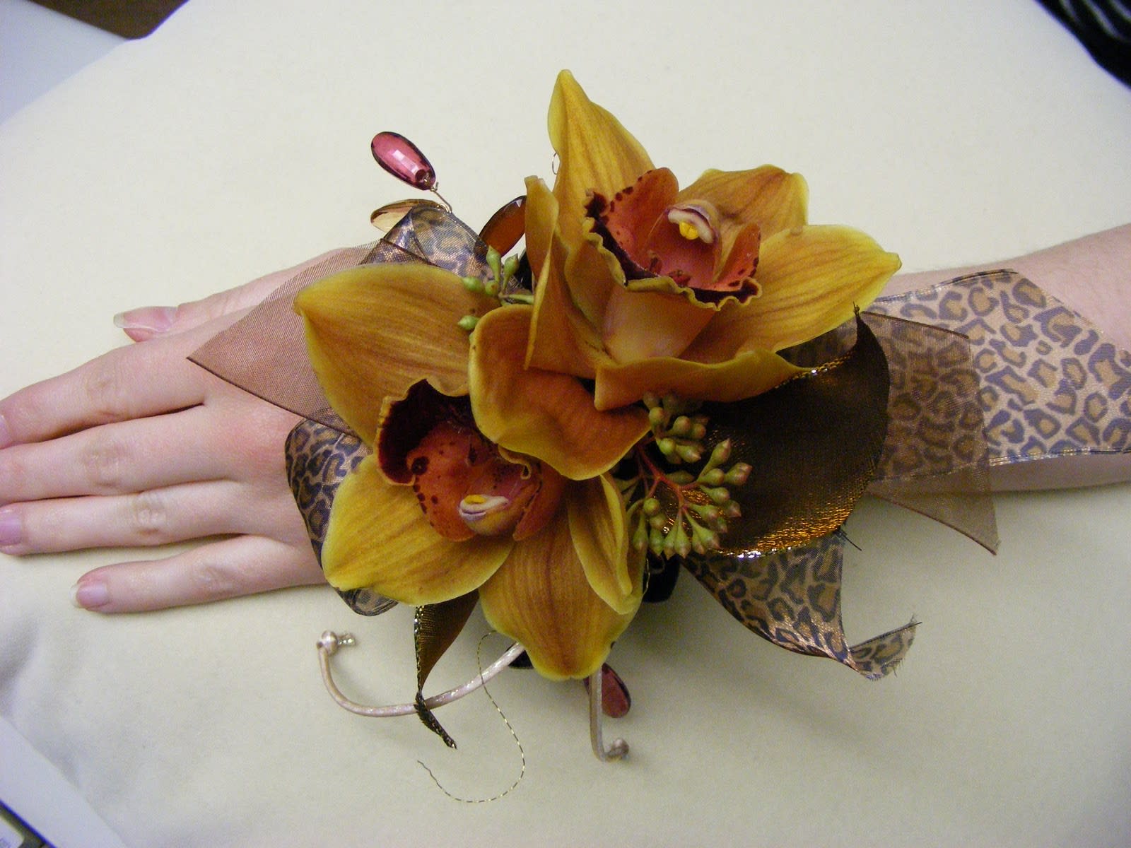 Yellow orchid corsage with leopard-print ribbon on a wrist