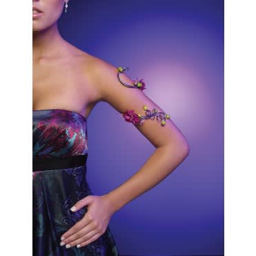 Woman wearing floral arm jewelry and a strapless dress against a purple background