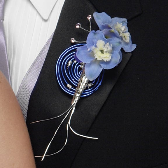 Blue flower boutonniere pinned to a black suit jacket