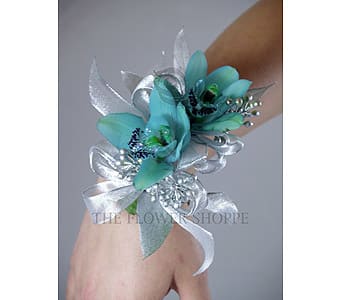 Blue floral wrist corsage with silver ribbon on a person's wrist
