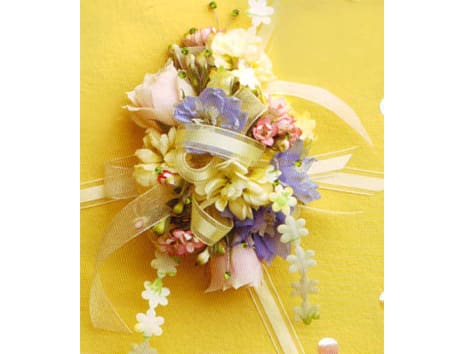 Pastel floral corsage with ribbon on a yellow background