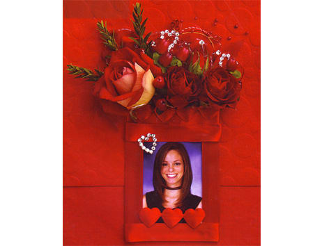 Red rose arrangement above a framed portrait with heart accents