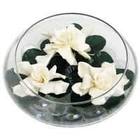White flowers arranged in a clear round box with dark green accents