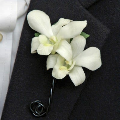 White orchid boutonniere on a dark suit jacket