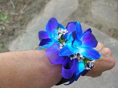 Blue and purple flower wrist corsage on a person's wrist
