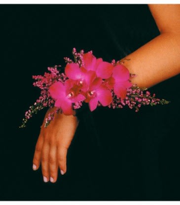 Pink orchid wrist corsage on a person's wrist