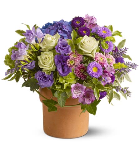 Purple and white mixed flower arrangement in a brown vase
