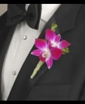 Pink orchid boutonniere pinned to a black suit jacket