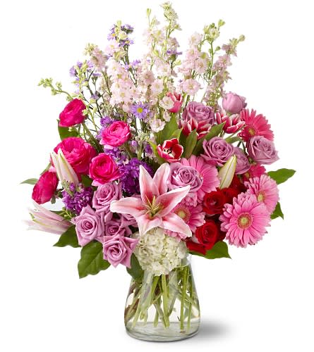 Mixed pink and purple flower bouquet in a clear glass vase
