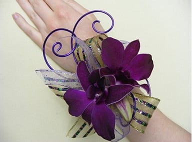 Purple orchid wrist corsage with ribbon on a wrist