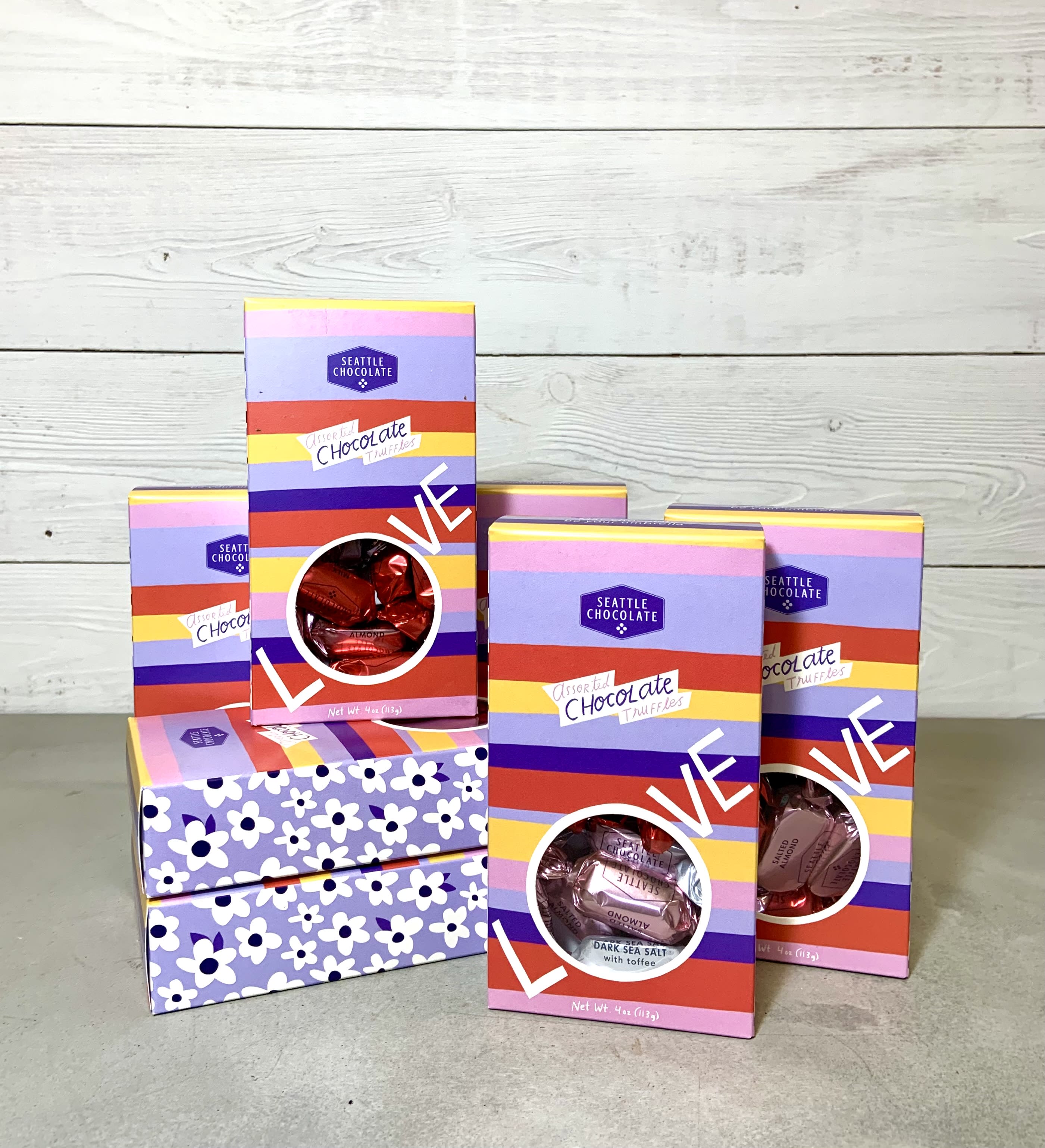 Assorted chocolate truffle gift boxes stacked on a tabletop