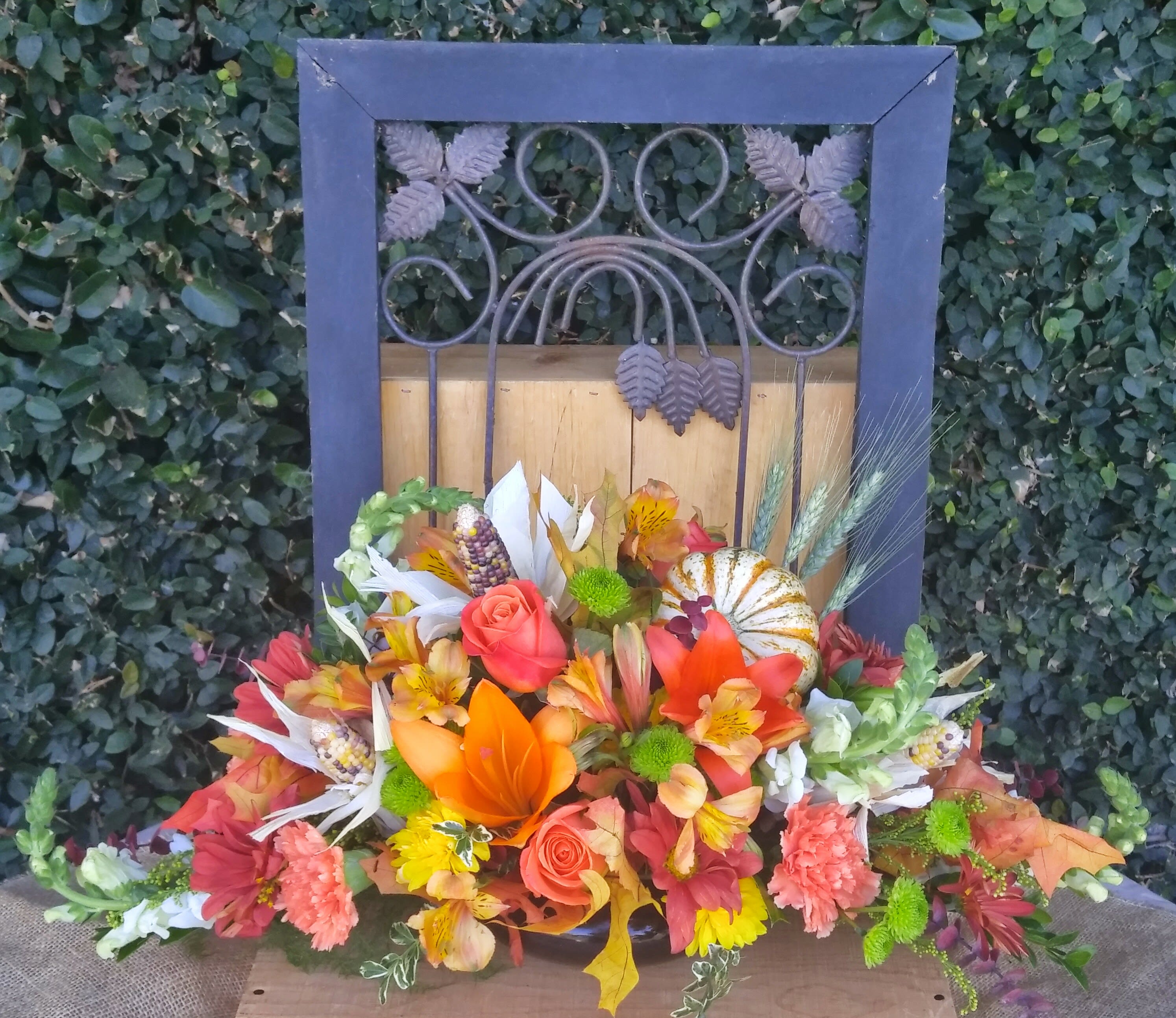 Fall Table Centerpiece - Nothing dresses up a Thanksgiving table like a fresh harvest centerpiece. Lilies, roses, snapdragons, pumpkins, dried corn and seasonal flowers come together in a festive design. 
