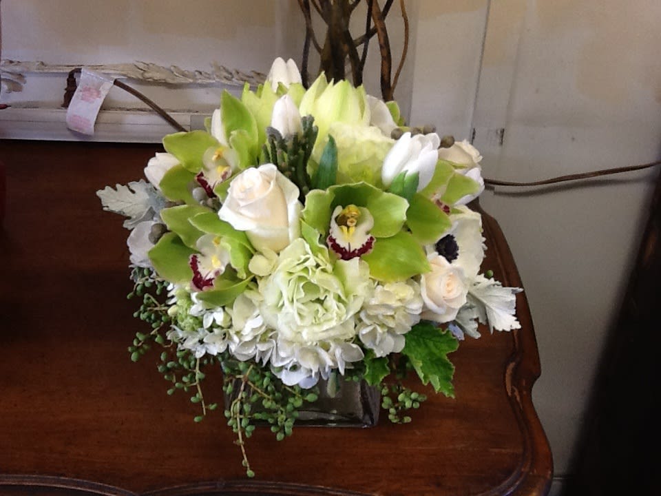 White and green floral arrangement in a square vase
