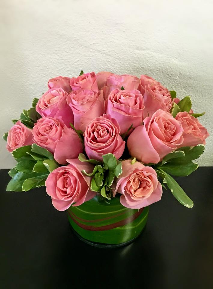Pink roses arranged in a green round vase