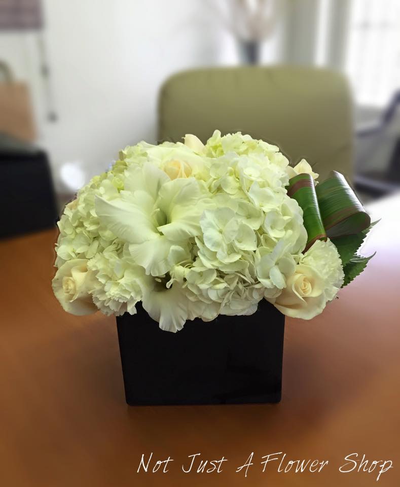 White floral arrangement in a black square vase