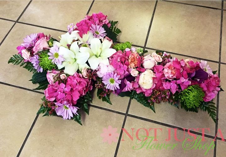 Pink and white floral casket spray with lilies and daisies