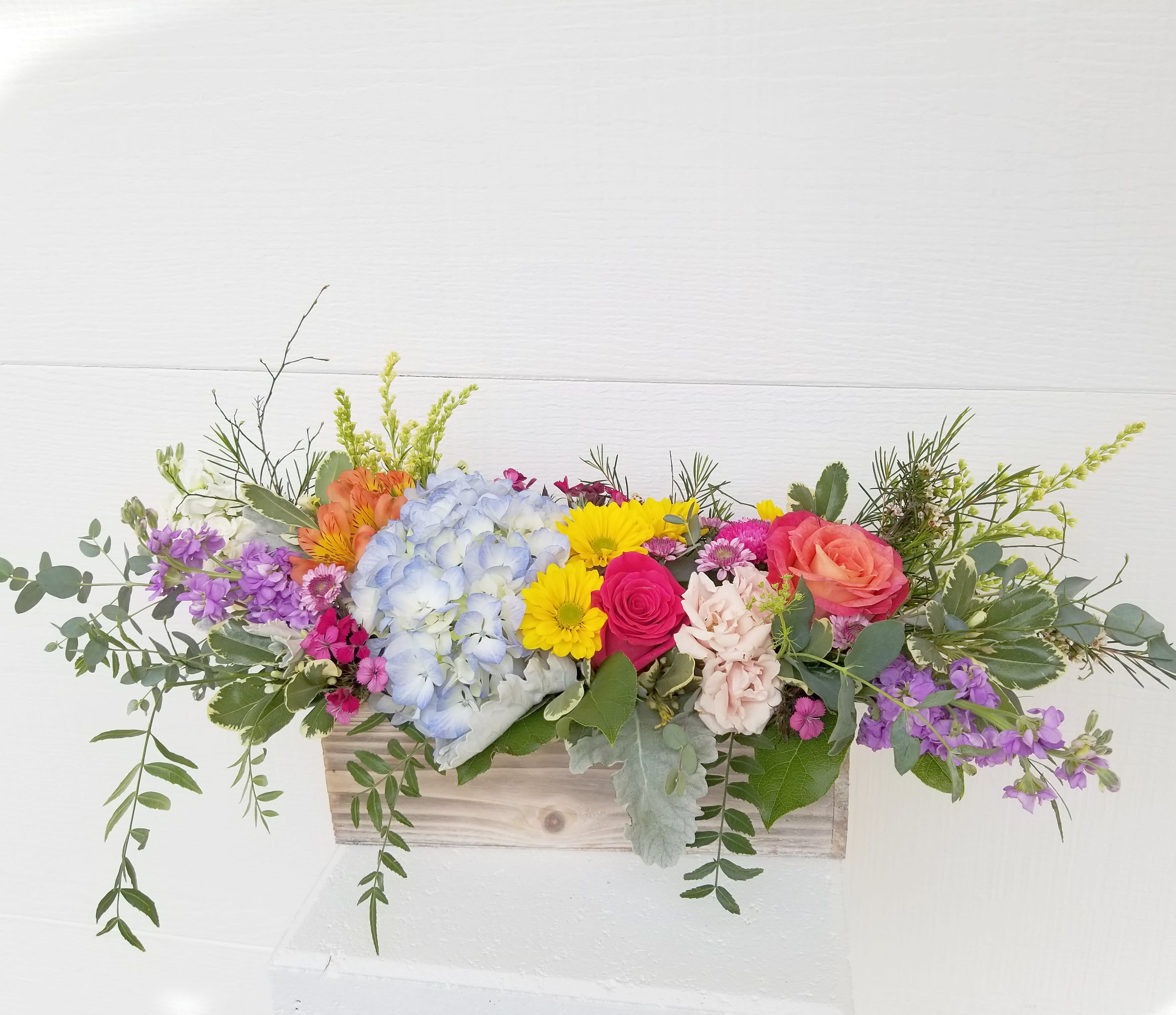 Colorful mixed flower arrangement in a wooden box