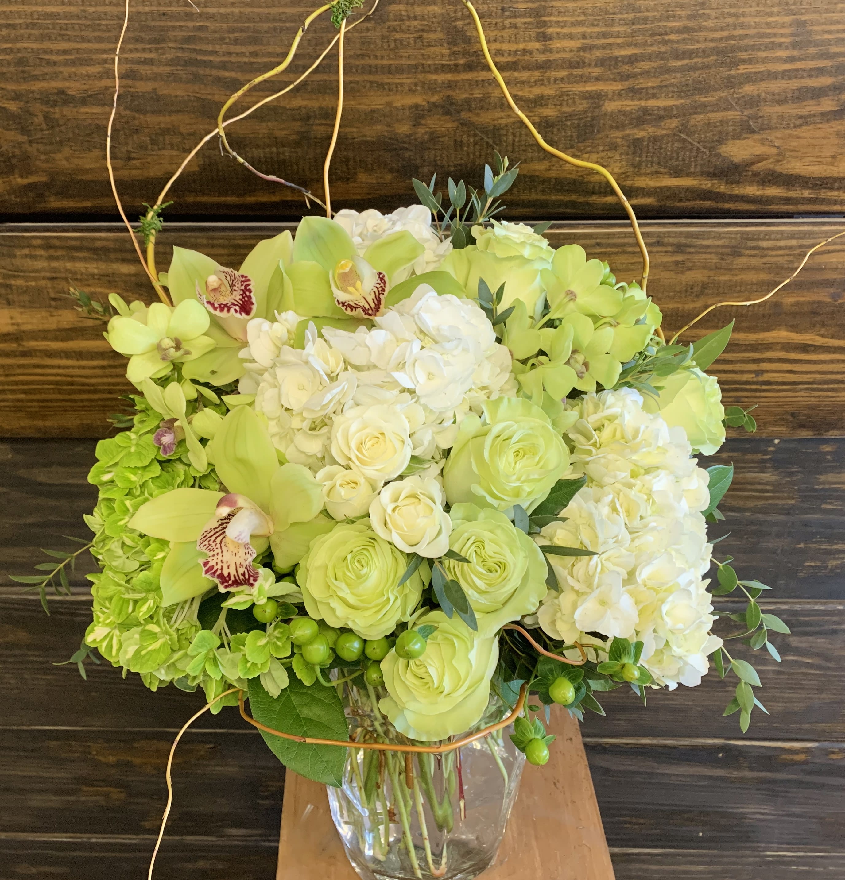 Lime green and white floral arrangement in a clear glass vase