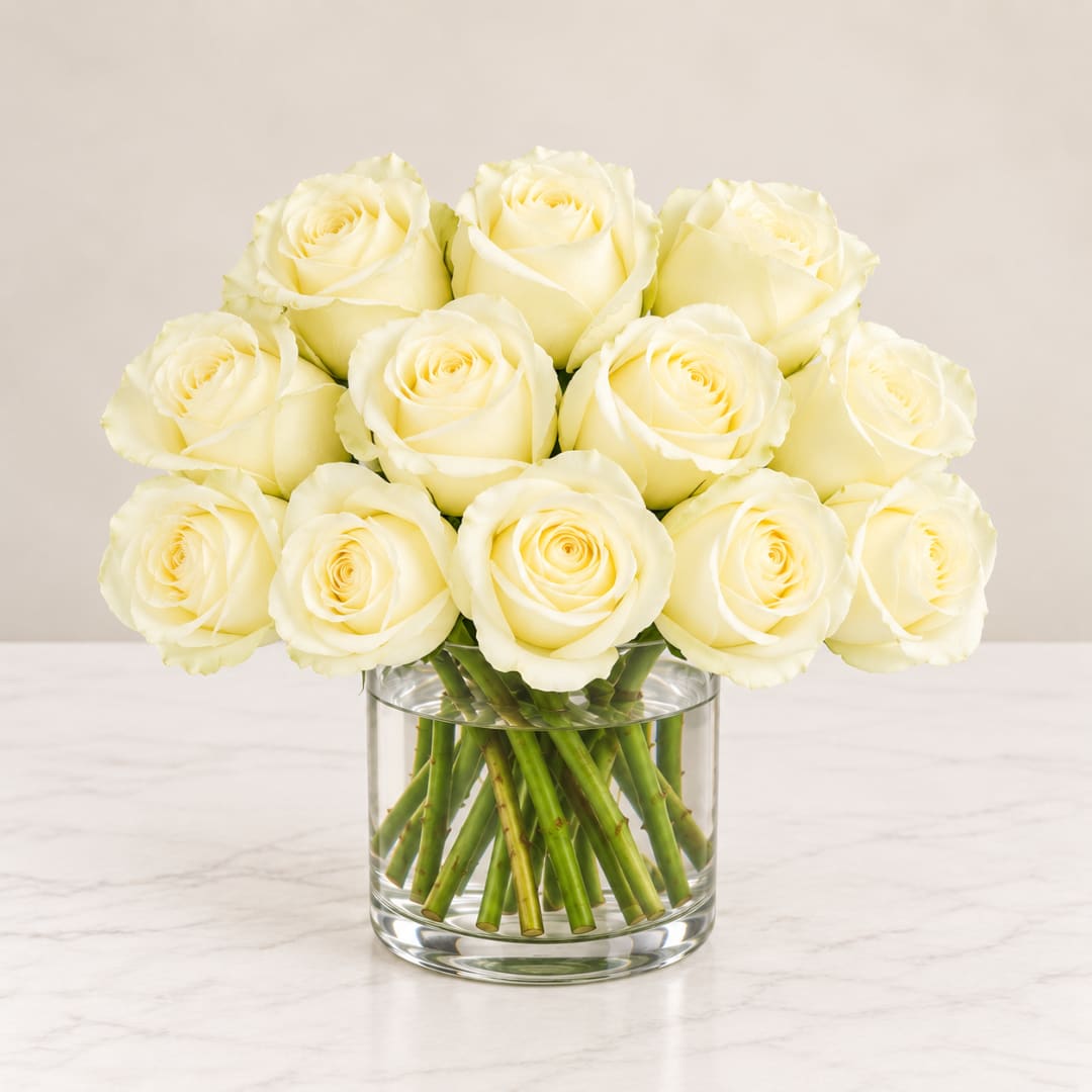 Bouquet of cream white roses in a clear glass vase