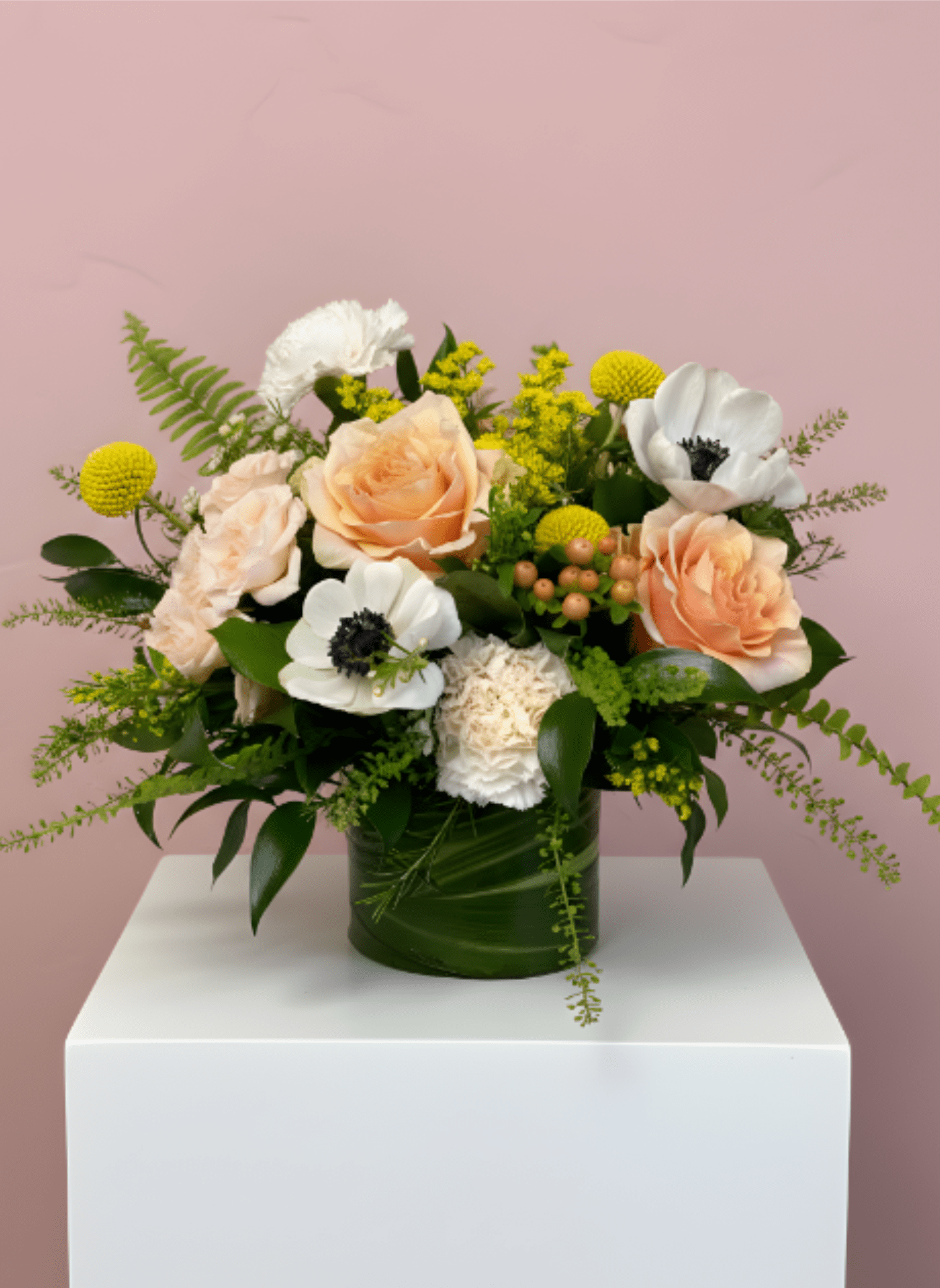Peach roses and white anemones in a green vase