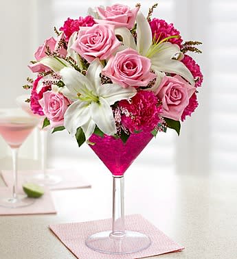 Cosmopolitan Bouquet - Product ID: 95264  EXCLUSIVE If theyâve got a taste for all things trendy, weâve got just the gift! This hand-arranged bouquet, from our signature floral cocktail collection, is artistically designed with pink roses, white lilies and pink carnations in an oversized martini glass to help celebrate any occasion in style! Truly original arrangement of pink roses, white lilies, carnations, calcynia and salal Hand-designed by our expert florists in an oversized acrylic martini glass filled with ruby-red crystal gel and finished with a green lime slice pick; glass measures 9"H Extra large arrangement measures approximately 16"H x 8.5"L Large arrangement measures approximately 15"H x 8"L Medium arrangement measures approximately 14"H x 7.5"L Small arrangement measures approximately 13"H x 7"L Our florists select the freshest flowers available so colors and varieties may vary Lilies may arrive in bud form and will open to full beauty over the next 2-3 days