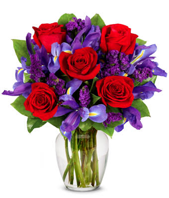 Ruby Rose Bouquet - Rubies are red...and so are the roses in this romantic arrangement all set to take someone's breath away. Purple statice, blue iris and a lovely clear garden vase also contribute effortlessly to a look of total beauty. Small Measures 16"H X 10"L. Medium Measures 17"H X 11"L. Large measures 18"H X 12"L.
