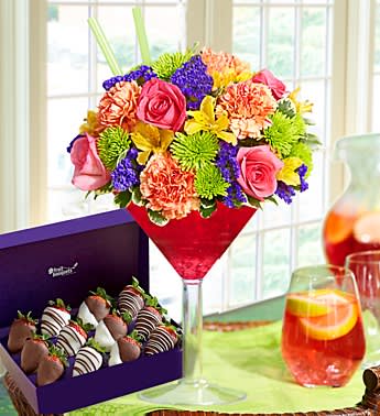 Strawberry Party Potion - Product ID: 102201  Raise a glass to the sweetest gift around! Lush, ripe strawberries, dipped and decorated to perfection, are paired with a kaleidoscope of roses, carnations and more in a chic martini glass. Available in counts of 12 strawberries Delivered fresh to their door with Same-Day Delivery Paired with a vibrant arrangement of roses, carnations, alstroemeria, poms, statice and variegated pittosporum Artistically hand-designed by our florists in an oversized acrylic martini glass filled with ruby red crystal gel; glass measures 10.5"H Large arrangement measures approximately 14"H x 9"W Medium arrangement measures approximately 13"H x 8.5"W Small arrangement measures approximately 12"H x 8"W Our florists select the freshest flowers available so colors and varieties may vary