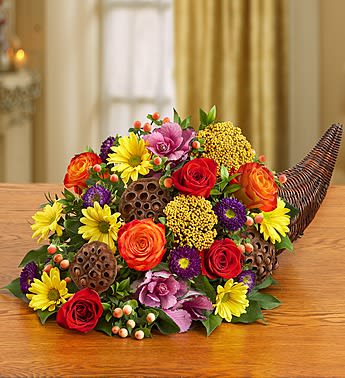 Fresh Flower Cornucopia - Product ID: 91928  Smiles will be plentiful this season when you send our fresh cornucopia centerpiece. Hand-designed in a traditional Horn of Plenty basket with rich red &amp; orange roses, yellow poms and seasonal accents, this classic and colorful table setter belongs at the center of all your celebrations! Fresh arrangement of orange and red roses, yellow poms, amber hypericum, purple kale, yarrow, purple matsumoto aster and salal, accented throughout with dried lotus pods Crafted by our expert florists in a rustic cornucopia basket; measures 19"L Large arrangement measures approximately 11"H x 21"L Small arrangement measures approximately 10.5"H x 19"L Our florists hand-design each arrangement, so colors, varieties and container may vary due to local availability This gift is available in participating areas only. Enter the recipient's zip code, and select the delivery date for availability.