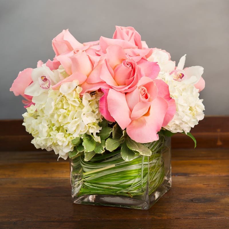 Pink roses and white hydrangeas in a square glass vase