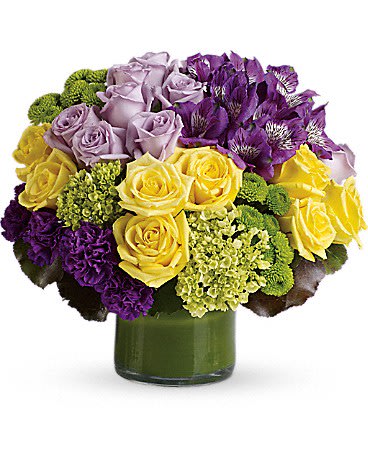Bouquet of purple, yellow, and lavender flowers in a green vase