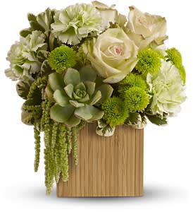 Compact arrangement of green succulents, white roses, and green blooms in a wooden cube vase