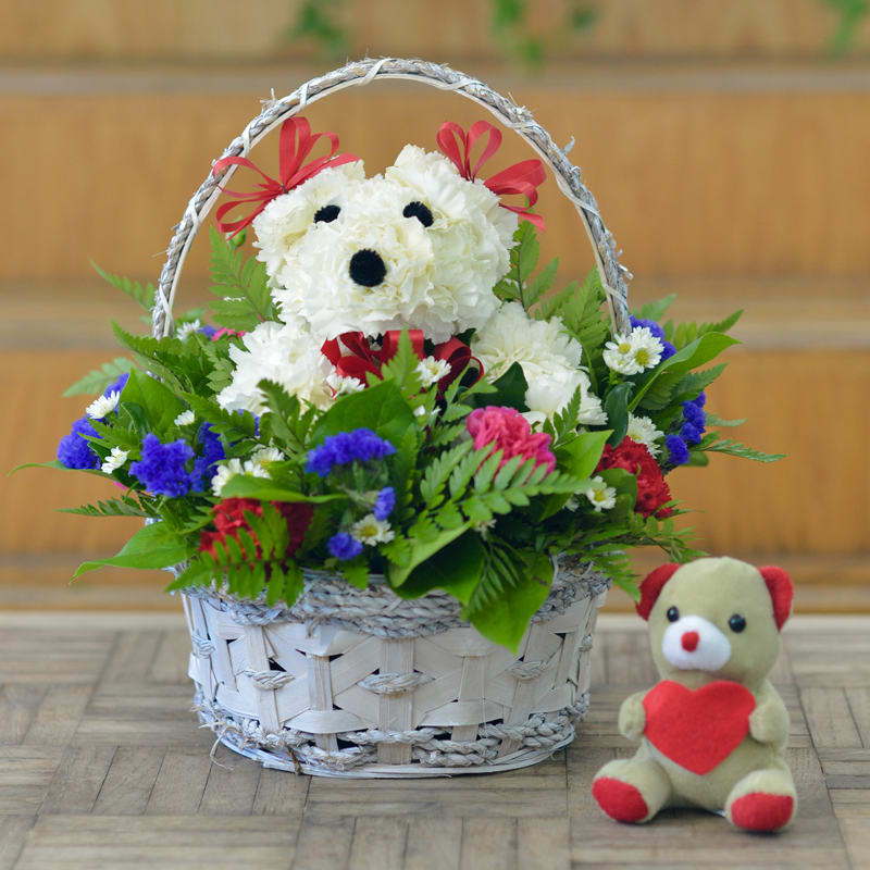 Basket arrangement with a teddy bear and white flower bear design