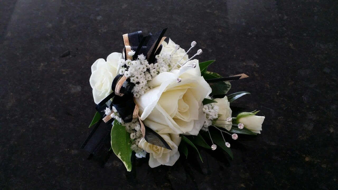 White rose corsage with black and gold ribbon accents