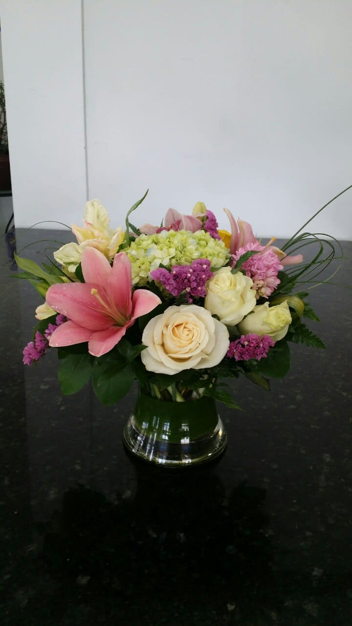 Pink lilies and cream roses in a glass vase