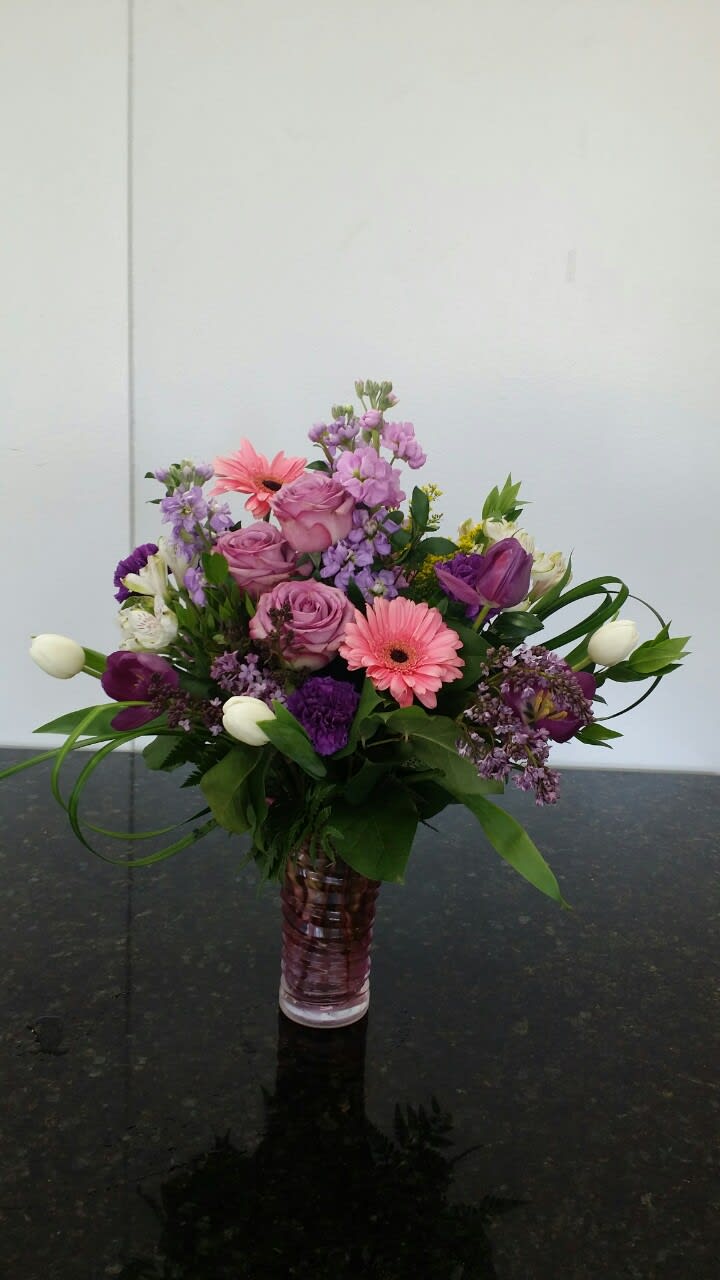 Pink and purple mixed flower arrangement in a glass vase