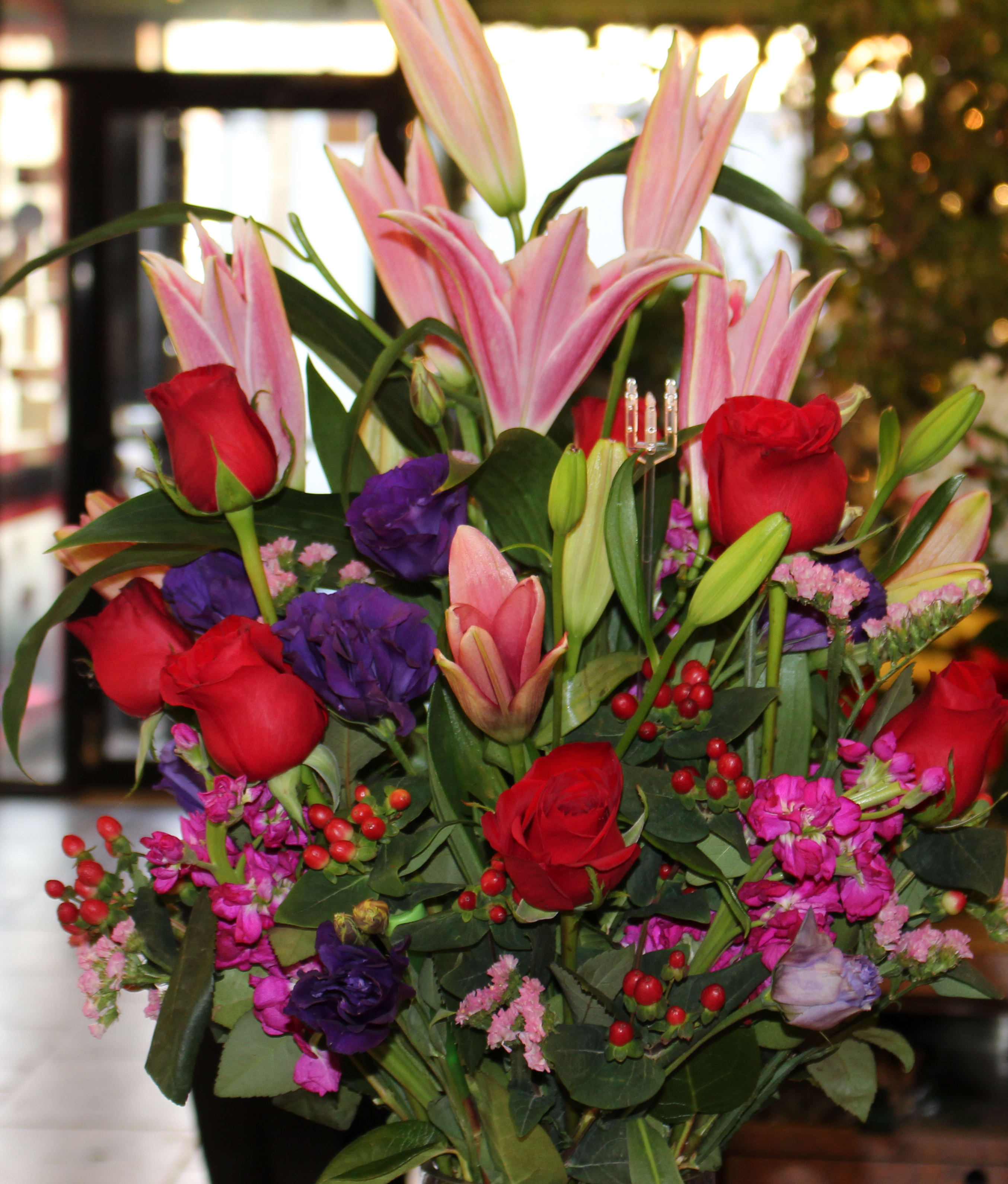 Bouquet of pink lilies and red roses with purple flowers